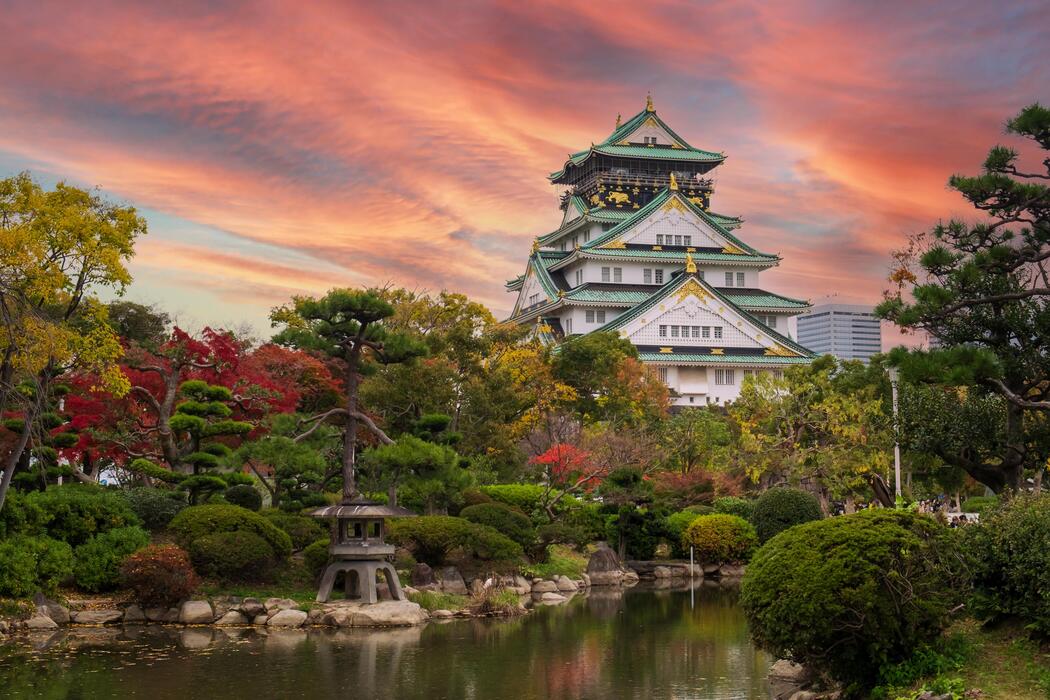 Osaka Castle with its towering main keep, stone walls, and surrounding gardens in Osaka, Japan.